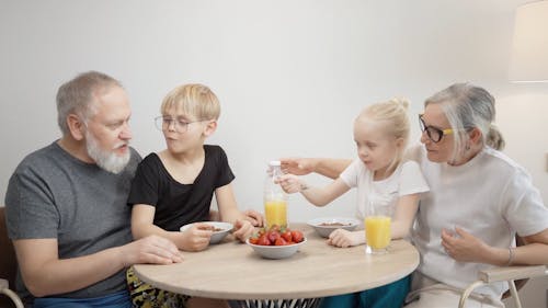 An Elderly Couple Eating Breakfast with their Grandchildren