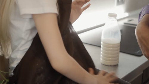 A Little Girl Removing Flour from Apron