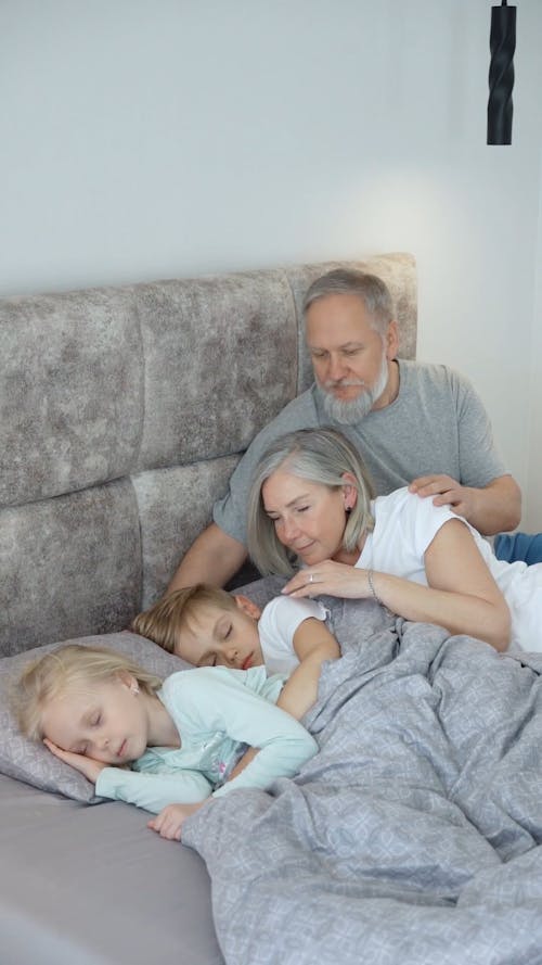 Children Sleeping on the Bed with Grandparents