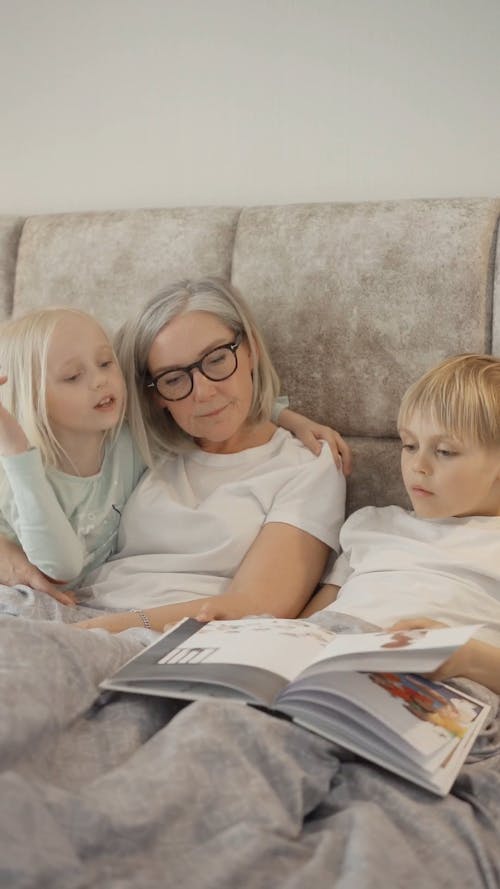 Elderly Woman Lying on Bed with Children