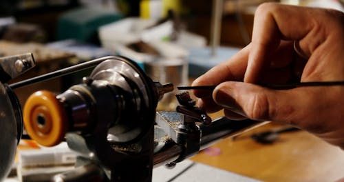 Close Up View of a Man Sharpening An Object