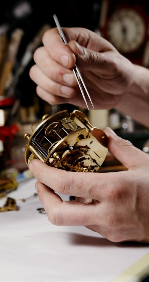 A Man Winding Up the Mechanical Part of the Clock