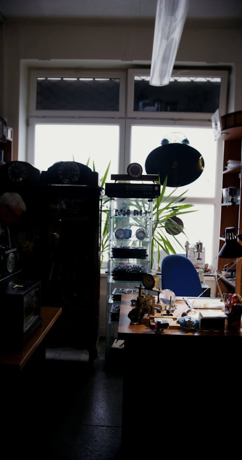 Elderly Man Walking Inside a Clock Repair Shop