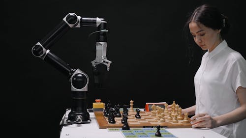 Young Woman Playing Chess with a Robot