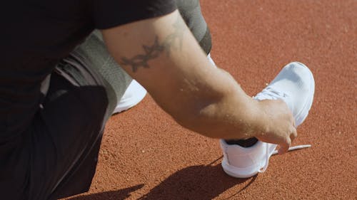 A Man with Prosthetic Leg Tying His Shoes