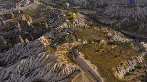 Aerial View of Colorful Hot Air Balloons Flying Above the Natural Rock Formations