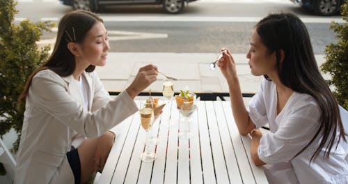 Female Friends In A Restaurant Eating Ice Cream