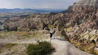 a couple and their baby standing on a mountain