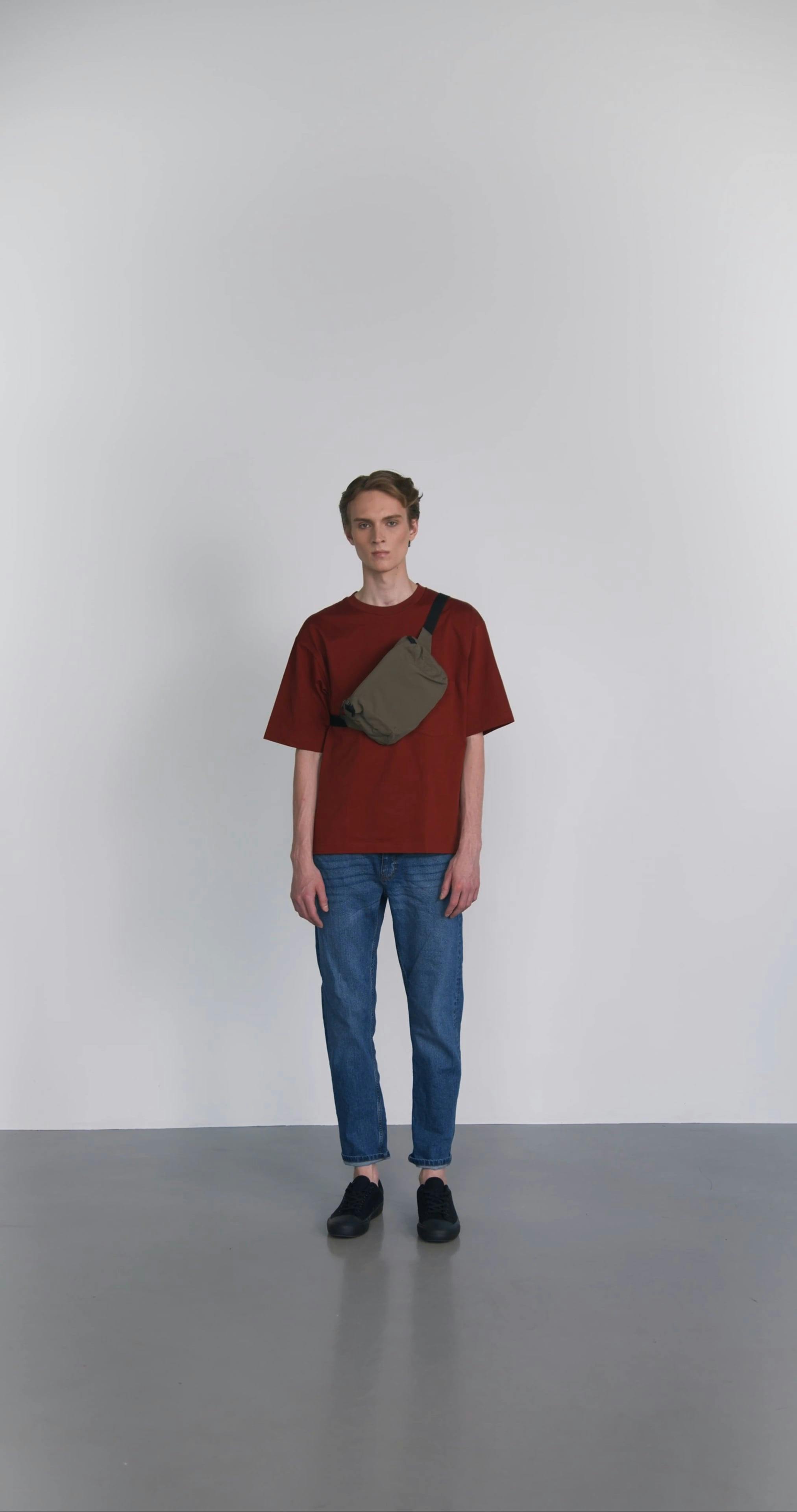 A Man Removing His Bag and Wearing Another Bag While Looking at the