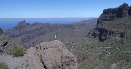 Arc Shot of a Woman Standing on a Geological Formation