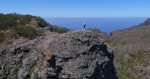 Drone Footage of a Woman Standing on a Geological Formation