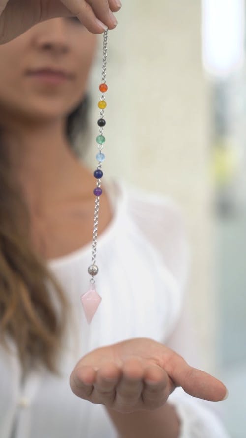 A Person Holding a Chakra Dowsing Pendulum