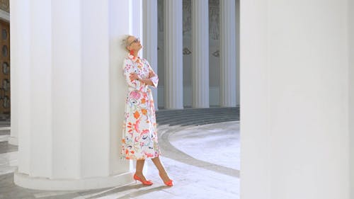 An Elderly Woman Posing on a Column