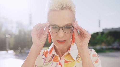 Close up of an Elderly Woman Taking off her Eyeglasses