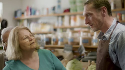 
A Store Attendant Talking to an Elderly Couple