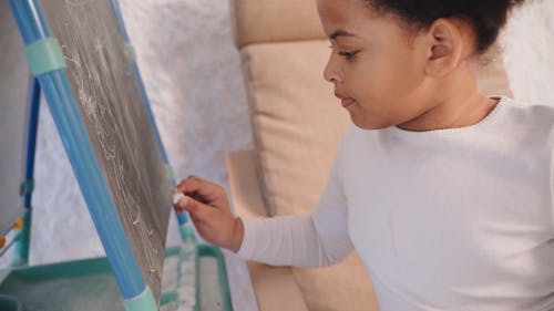 A Kid Drawing on the Chalkboard
