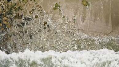 drone footage of a waves crashing on shore