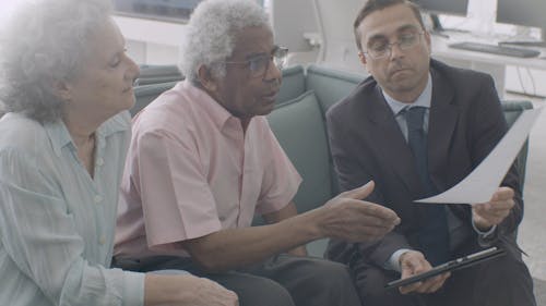 A Man Handing a Document to an Elderly Couple