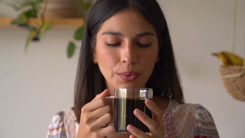 A Smiling Woman Holding a Cup of Coffee