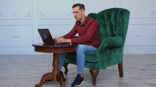 A Man Talking while Using His Laptop