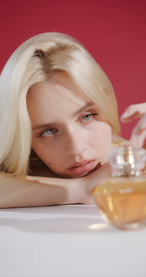 A Beautiful Woman Touching a Perfume Bottle