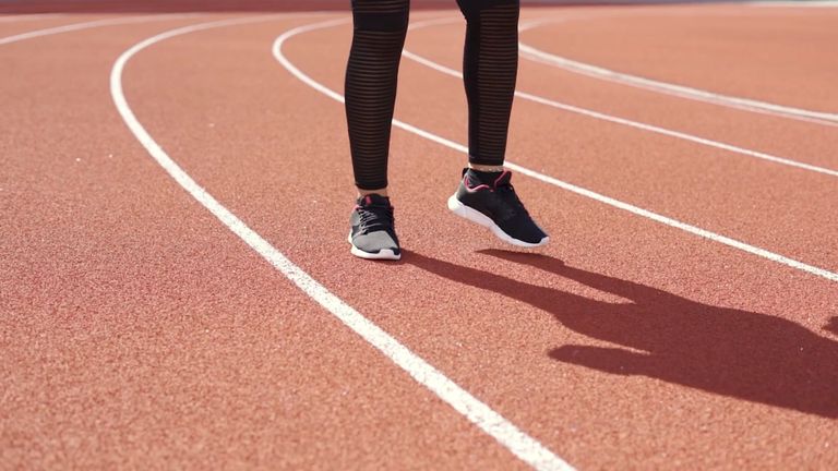 Athlete warming up on an outdoor track on a sunny day