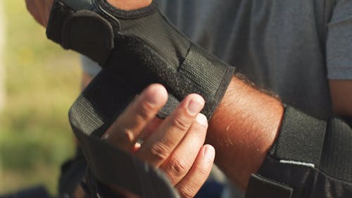 A Person Putting on Wrist Guards