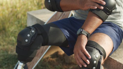 A Skateboarder Putting on Wrist Guards