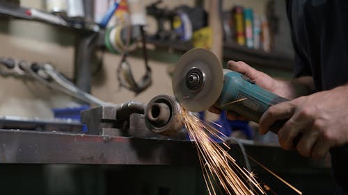 A Mechanic Cutting Metal Parts with a Grinder