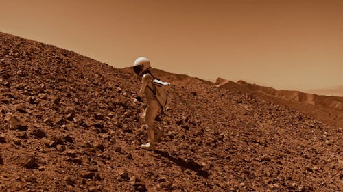 An Astronaut Walking up a Mountain