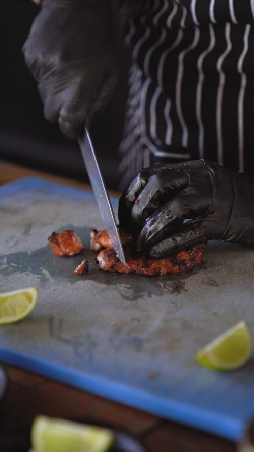 A Person Slicing a Grilled Steak