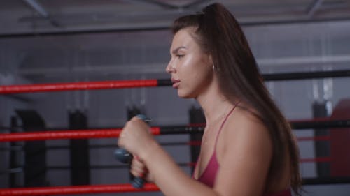 Woman Punching With Dumbbells