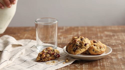 Person Eating Cookies with Milk