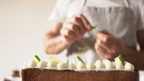 A Bearded Man Putting Leaves on a Cake