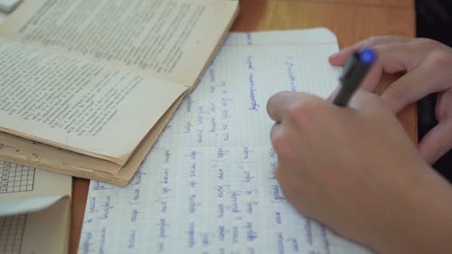 Close Up Video of a Person Writing on a Notebook