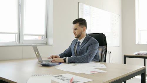 A Businessman Typing on His Laptop