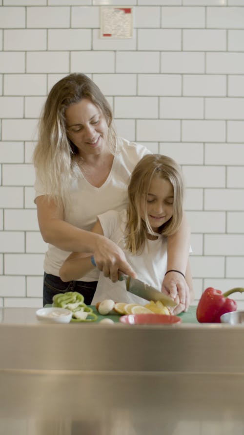 A Mother Teaching Daughter How to Use a Knife