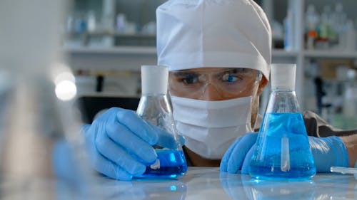 Chemist Looking at a Chemical Inside an Erlenmeyer Flask