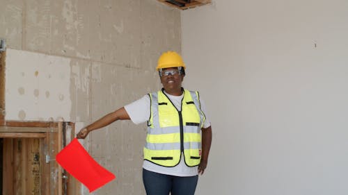 A Woman Wearing Safety Gear Waving a Red Flag
