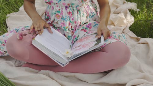 A Close Up of a Woman Reading a Book in the Outdoors