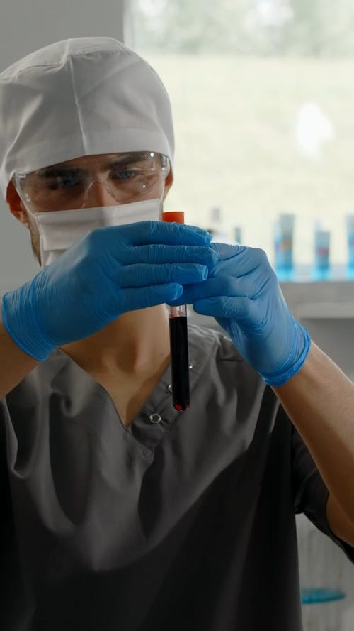 Chemist Looking at a Blood Inside a Test Tube