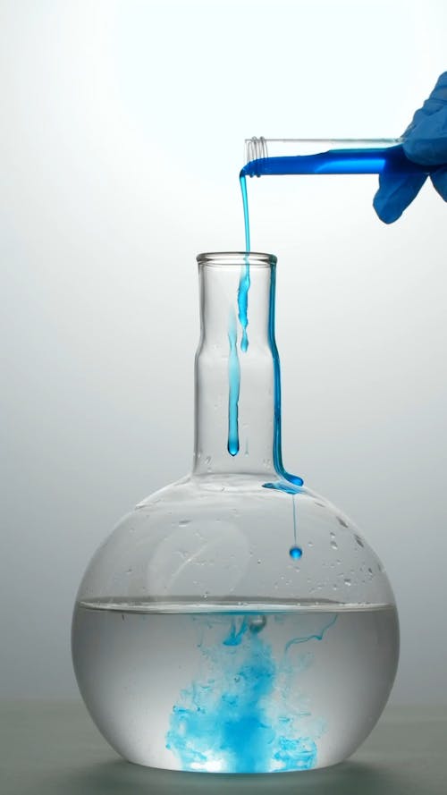 Blue Liquid being Poured into a Flat Bottomed Flask