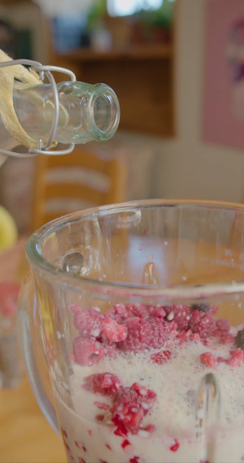 A Person Pouring Milk in the Glass