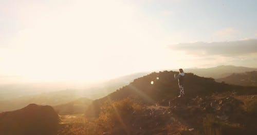 Aerial Footage of Woman Standing on a Cliff