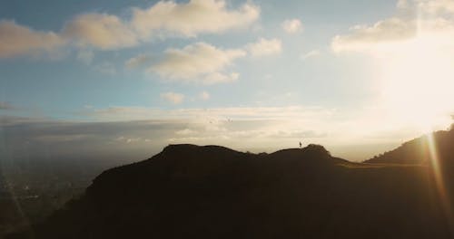 Aerial Footage of a Woman Running on a Hilltop