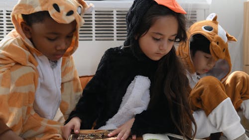 Children Reading a Book Together