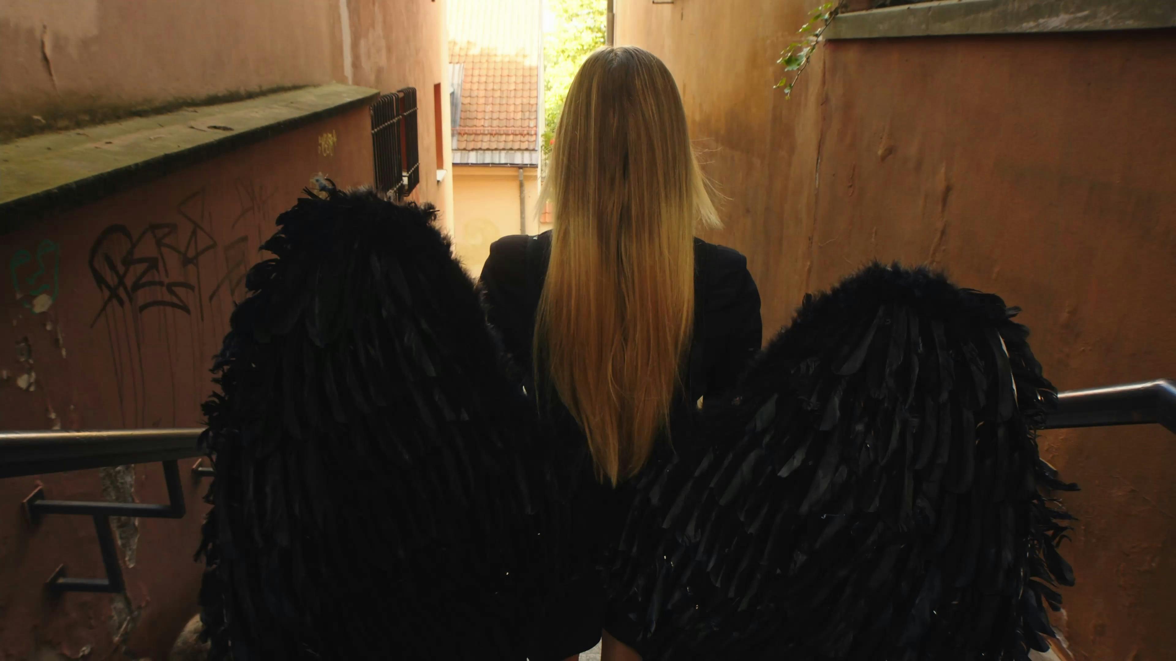 A Woman Wearing Black Angel Wings Walking Down a Flight of Stairs Free  Stock Video Footage, Royalty-Free 4K & HD Video Clip