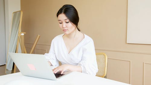 A Woman Typing on Laptop