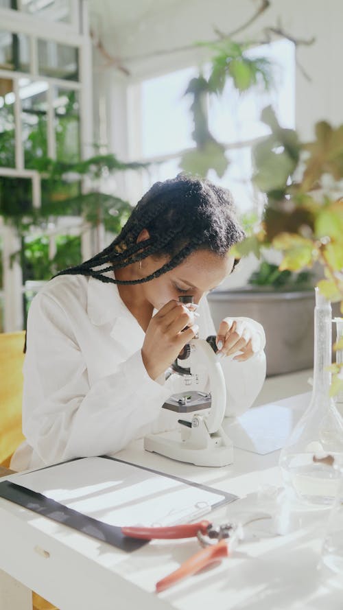 A Happy Female Botanist Using a Microscope