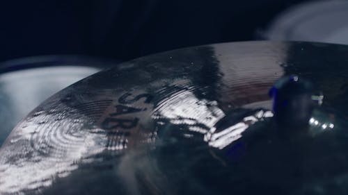 A Hand Playing the Drum and Cymbal
